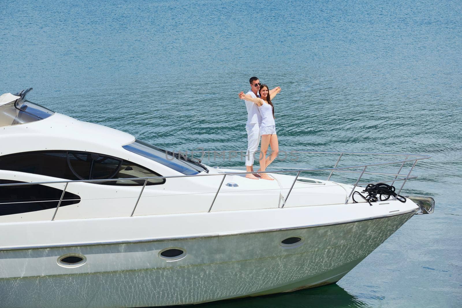 Romantic young couple spending time together and relaxing on yacht