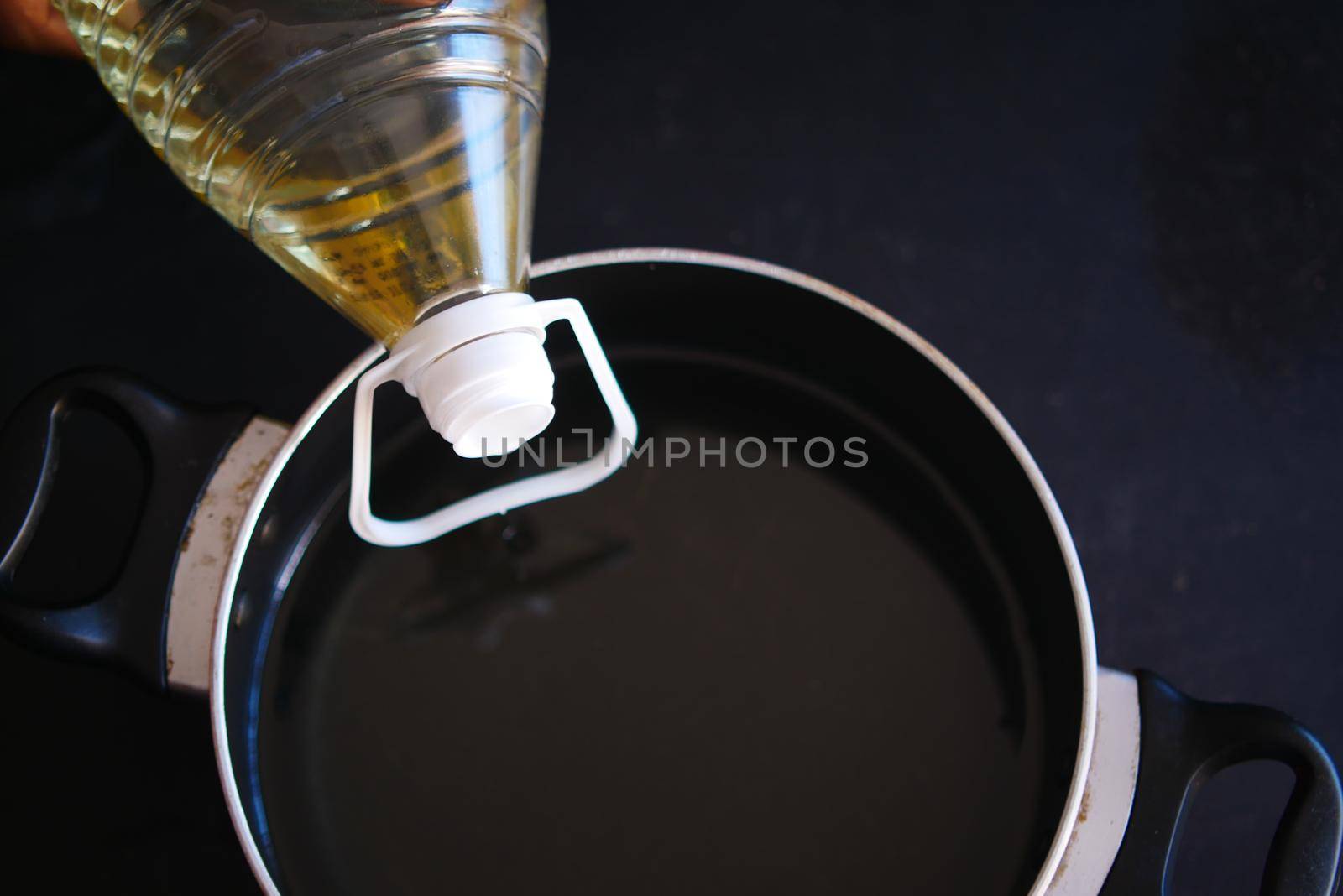 pouring sunflower oil in a pan .