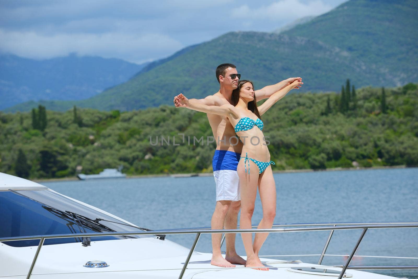 Romantic young couple spending time together and relaxing on yacht