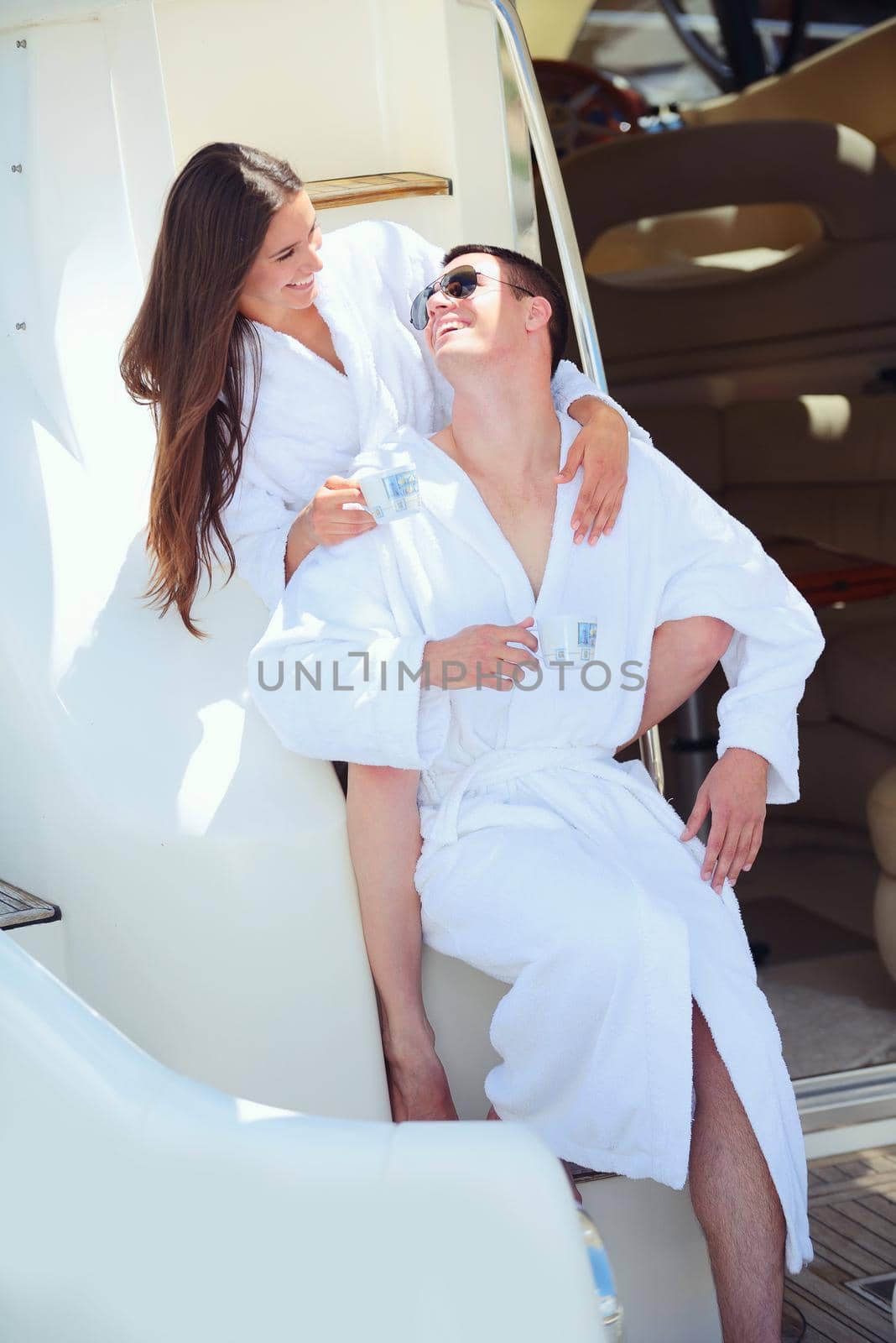 Romantic young couple spending time together and relaxing on yacht