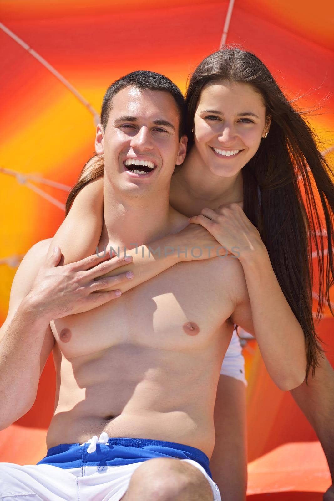 happy young couple have fun on beach by dotshock