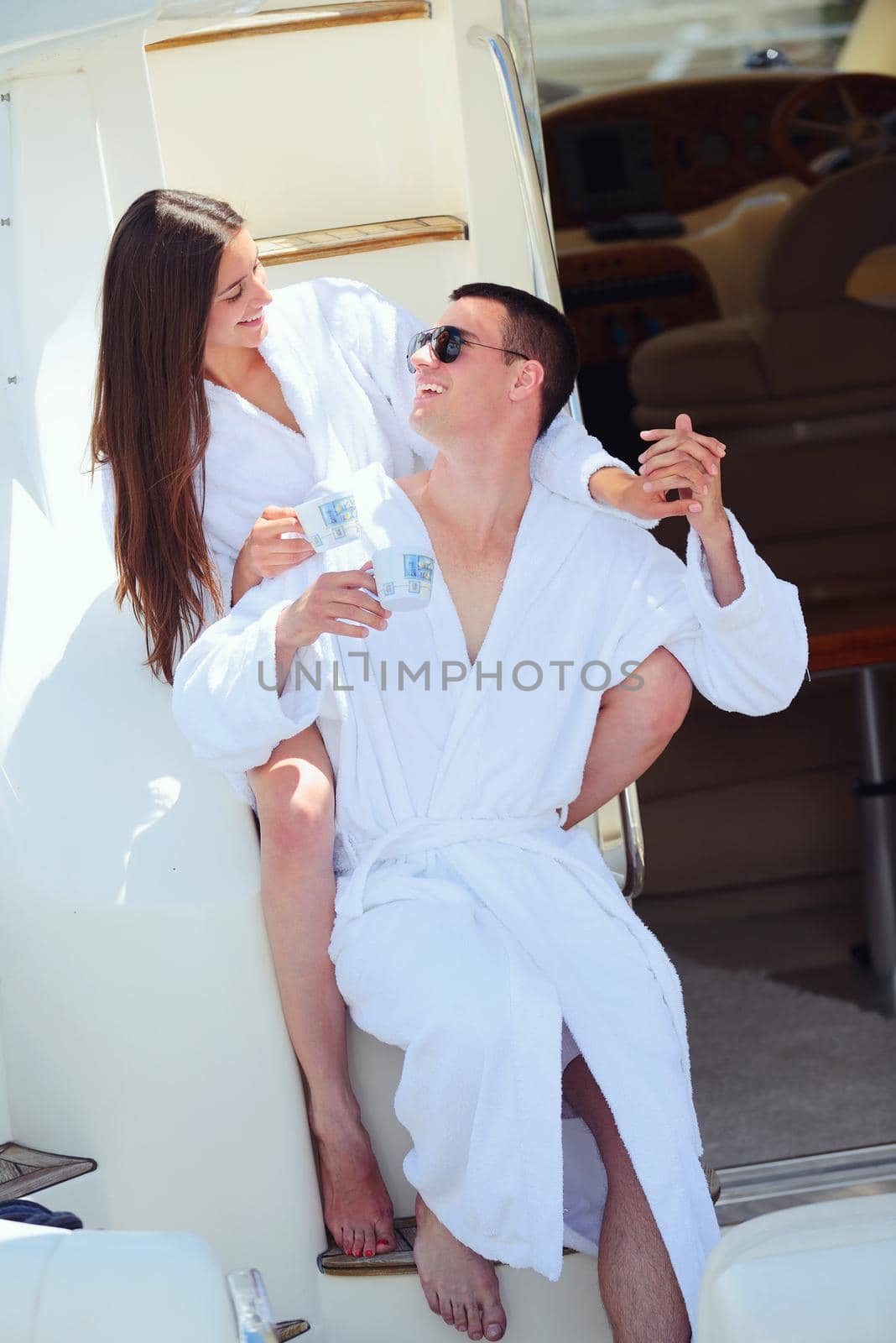 Romantic young couple spending time together and relaxing on yacht