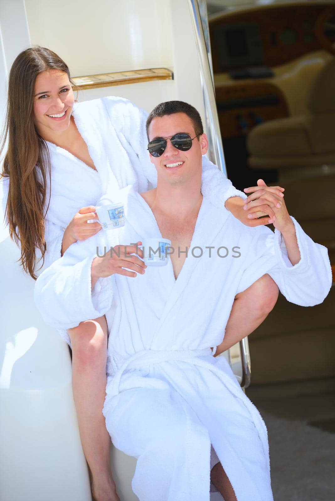 Romantic young couple spending time together and relaxing on yacht