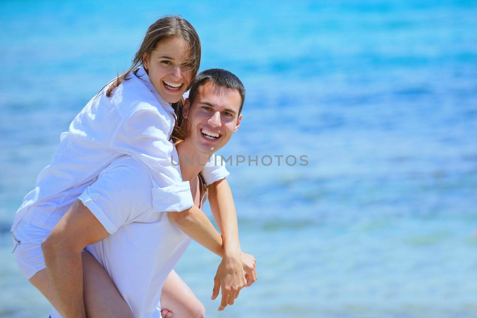 happy couple have fun on the beach by dotshock