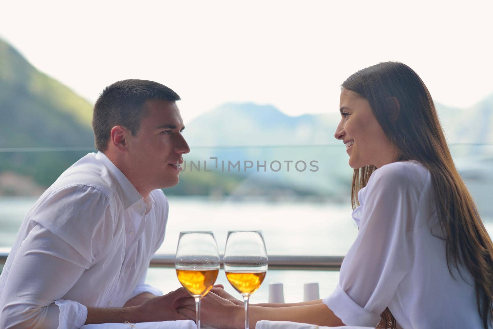happy young couple having lanch at beautiful restaurant on the beach