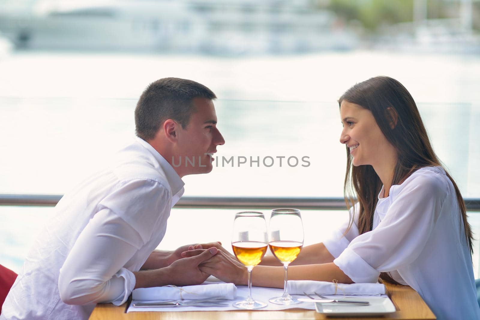 happy young couple having lanch at beautiful restaurant on by the sea on  beach