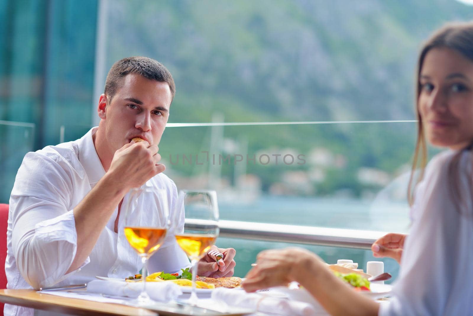 happy young couple having lanch at beautiful restaurant on by the sea on  beach