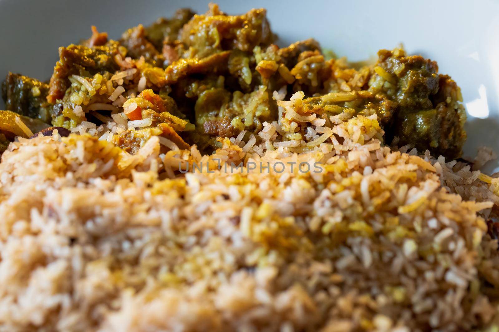 Close up of Jamaican Curried Goat served with rice and peas