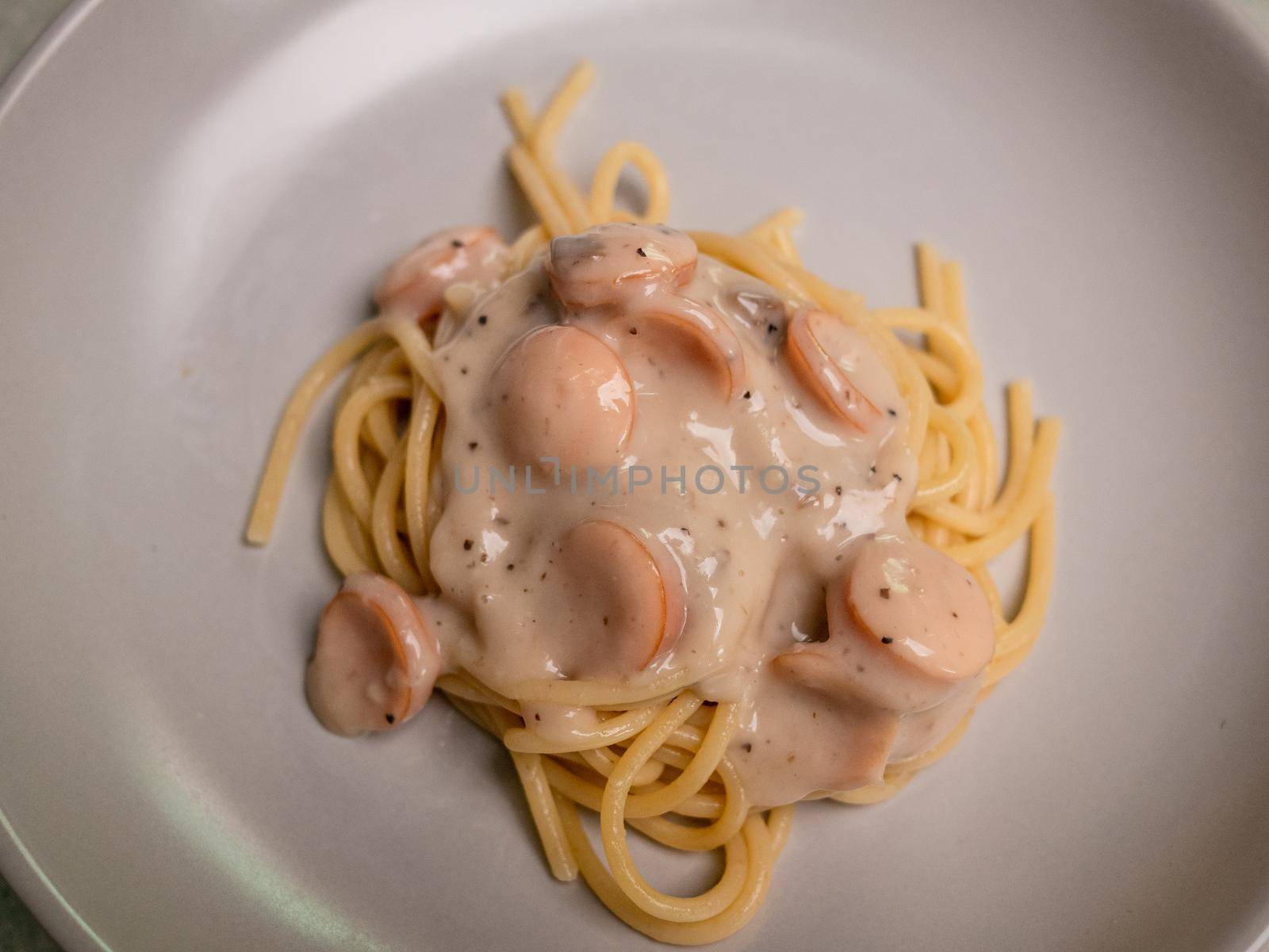 Spaghetti carbonara mushroom sauces with sausages in a plate. Healthy Italian Food and Cooking concepts. by TEERASAK