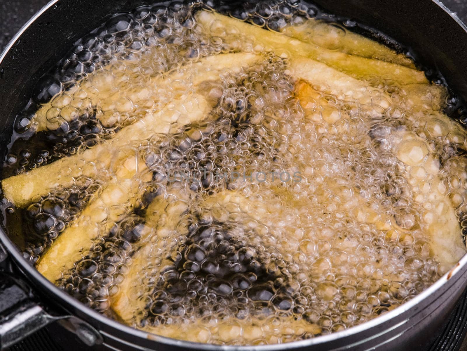 Close up of Frying french fries in the fryer in hot oil on the electric stove in the kitchen. Making homemade french fries. by TEERASAK