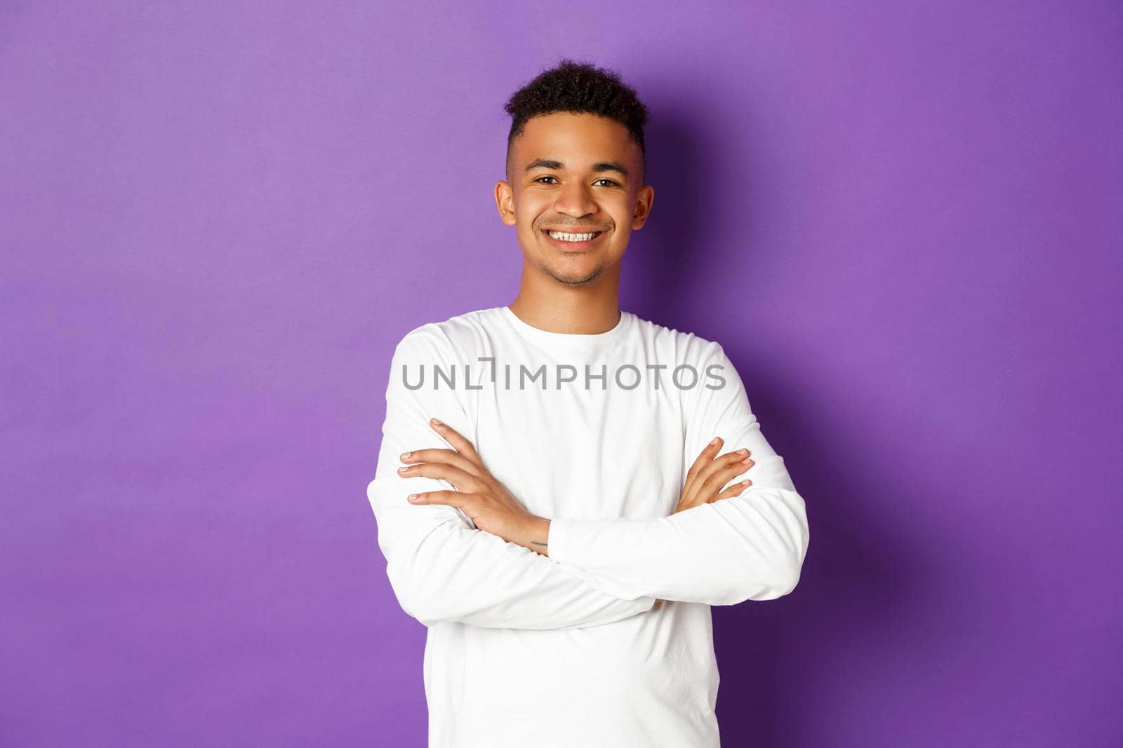 Image of confident african-american man, cross arms on chest and smiling with self-assured expression, standing over purple background by Benzoix