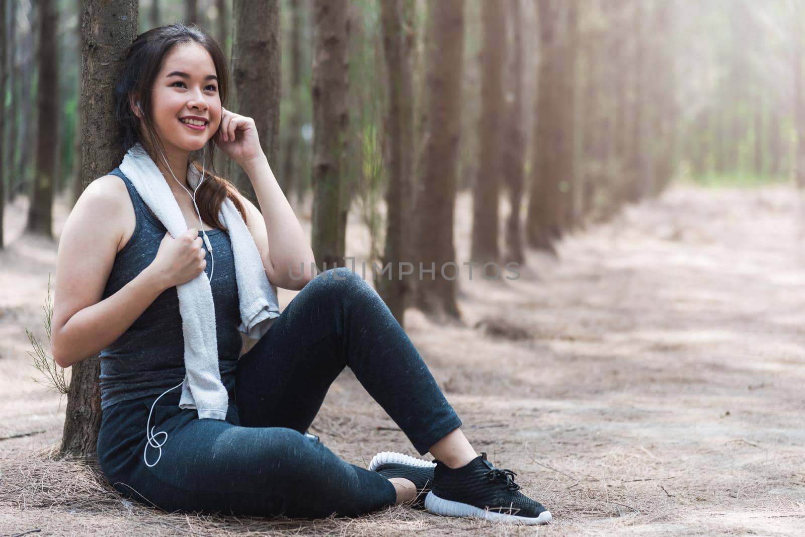 Beautiful sport young woman girl lifestyle exercise healthy drinking water from bottle after running workout in forest nature park with copy space