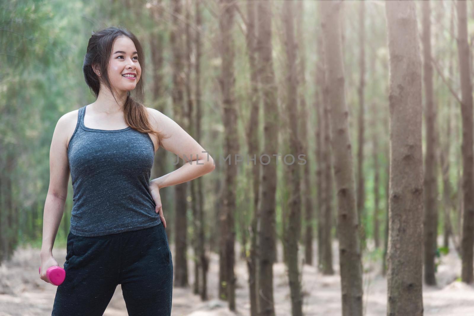 Sport young woman girl lifestyle relax holding fitness dumbbell workout in forest nature park with copy space