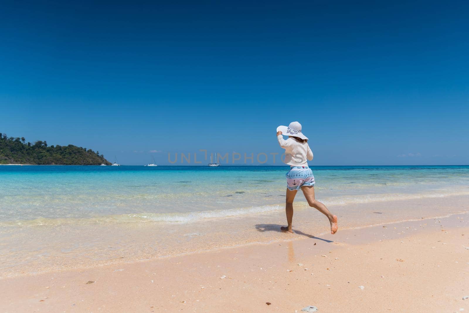 Happy young girl running to the beach at koh mook of Thailand
