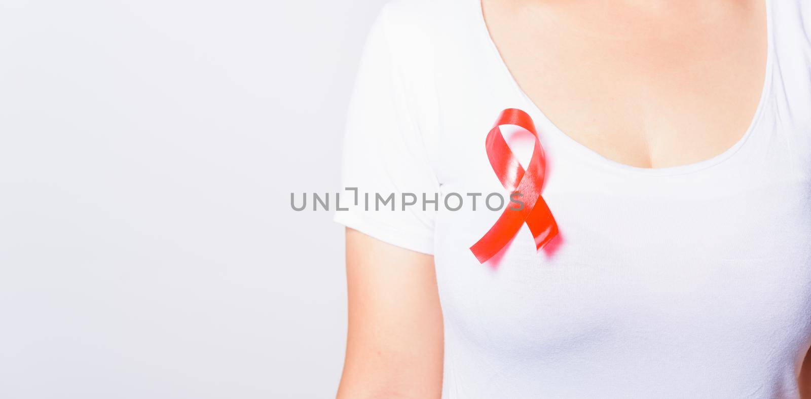 Closeup of female with red ribbon Support HIV AIDS on shirt, World AIDS Day and medicine concept with copy space for use on white background