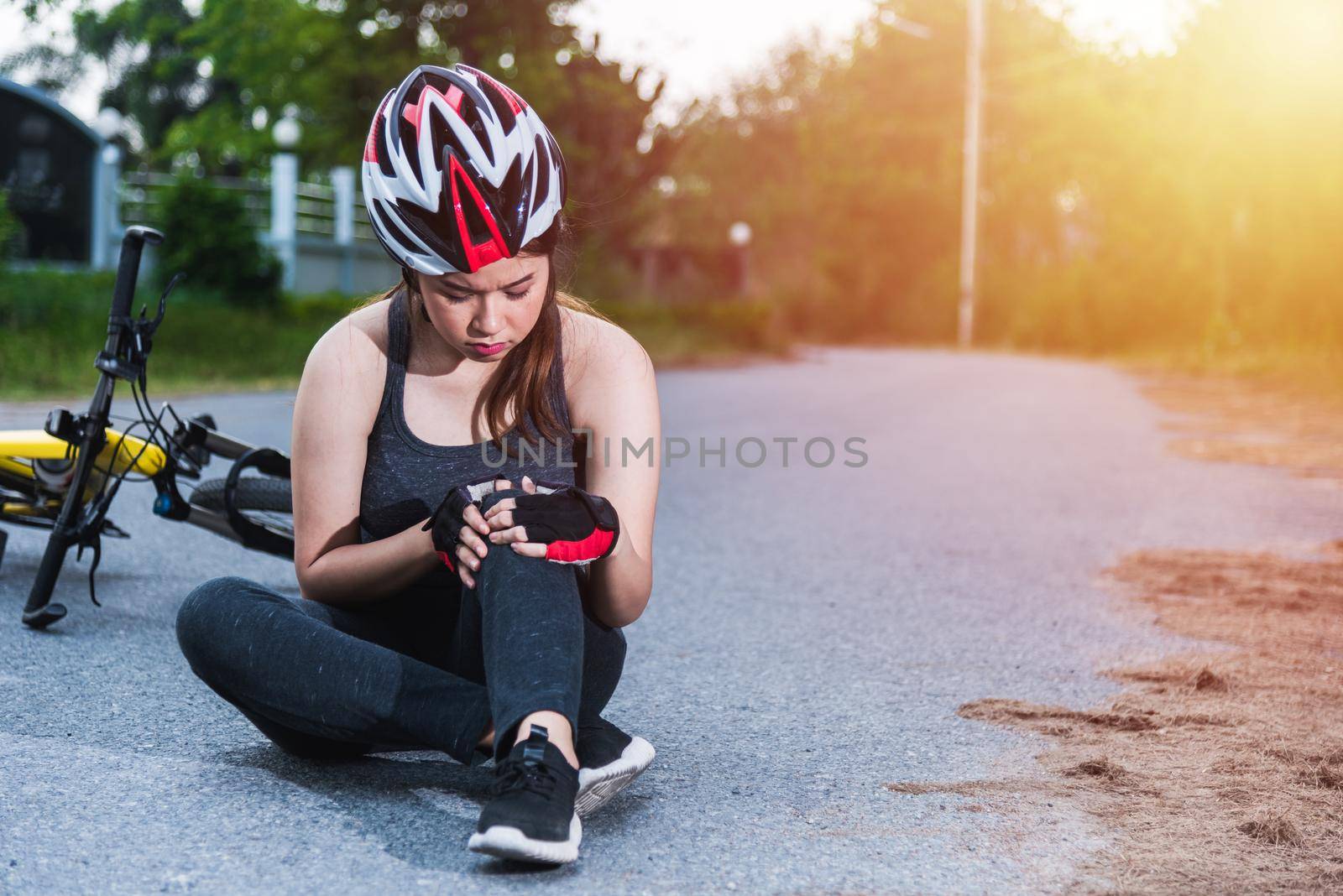 Beautiful young female woman pain injured accident sitting after bicycle falling with copy space