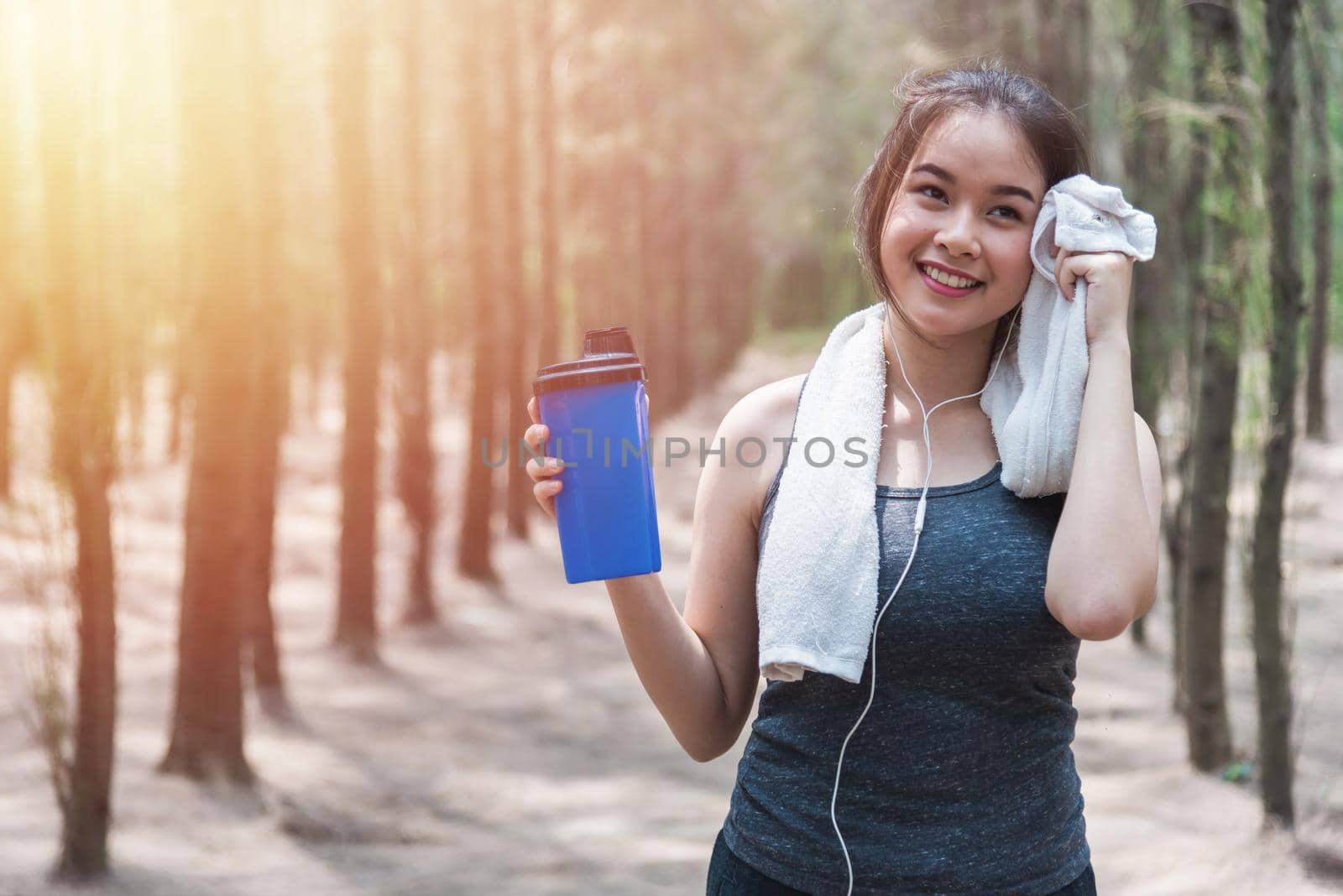 Sport beautiful young woman girl lifestyle exercise healthy drinking protein water after running workout in forest nature park with copy space