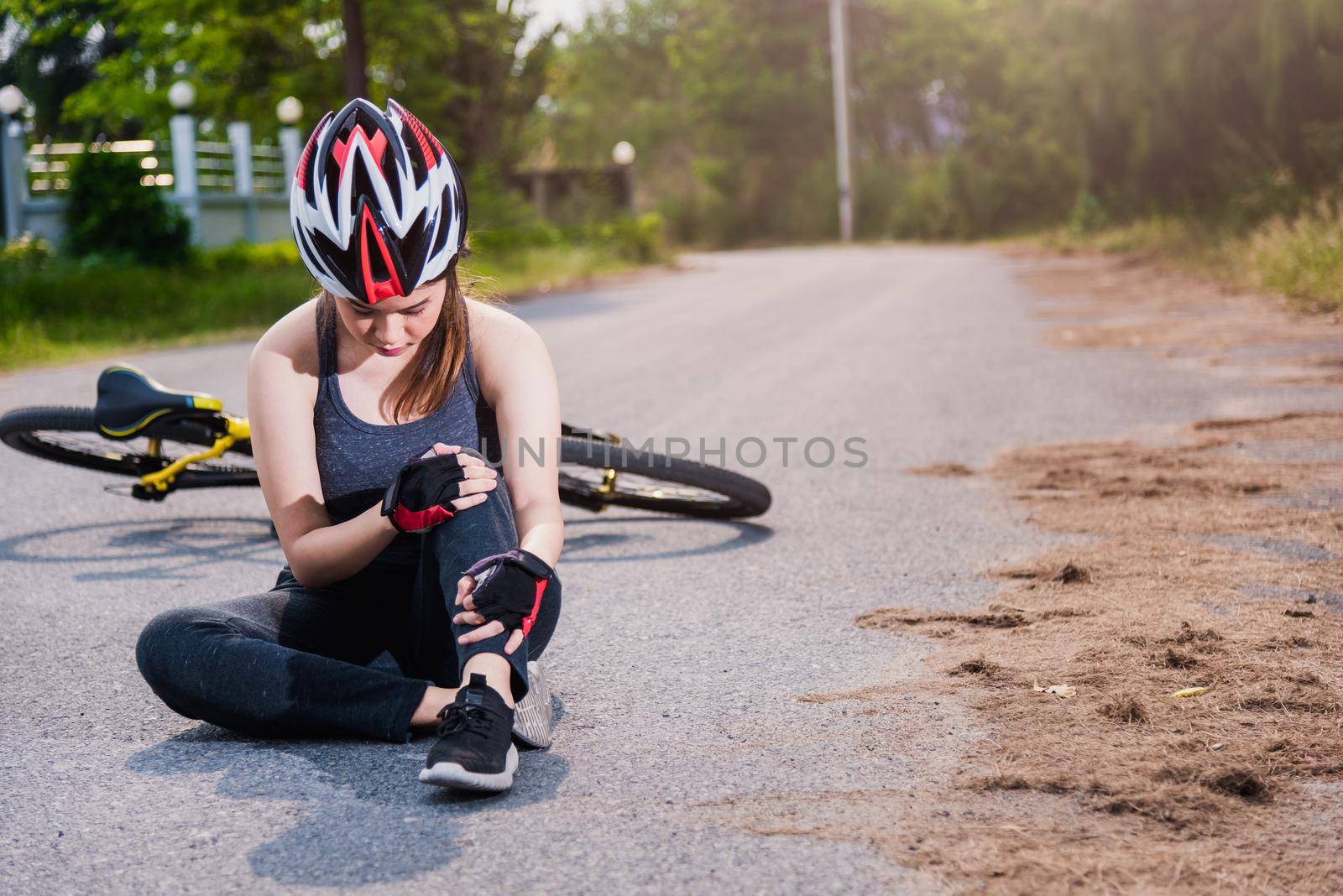 Beautiful young female woman pain injured accident sitting after bicycle falling with copy space