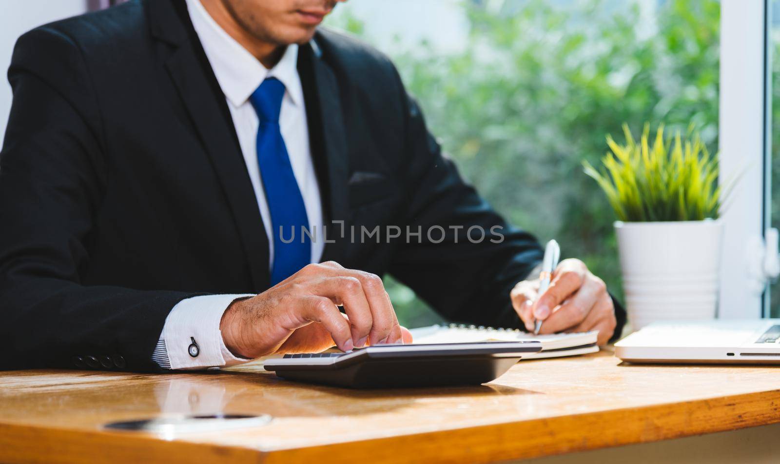 Business man accounting using calculating and work with laptop computer on desk office, finance concept