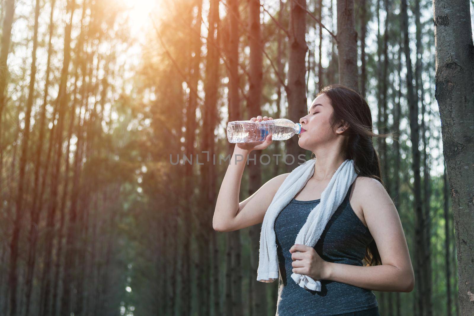 Beautiful young woman drinking water bottle after exercise fitness by Sorapop