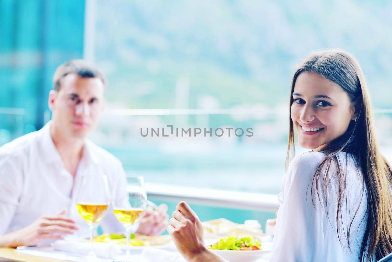 happy young couple having lanch at beautiful restaurant on by the sea on  beach