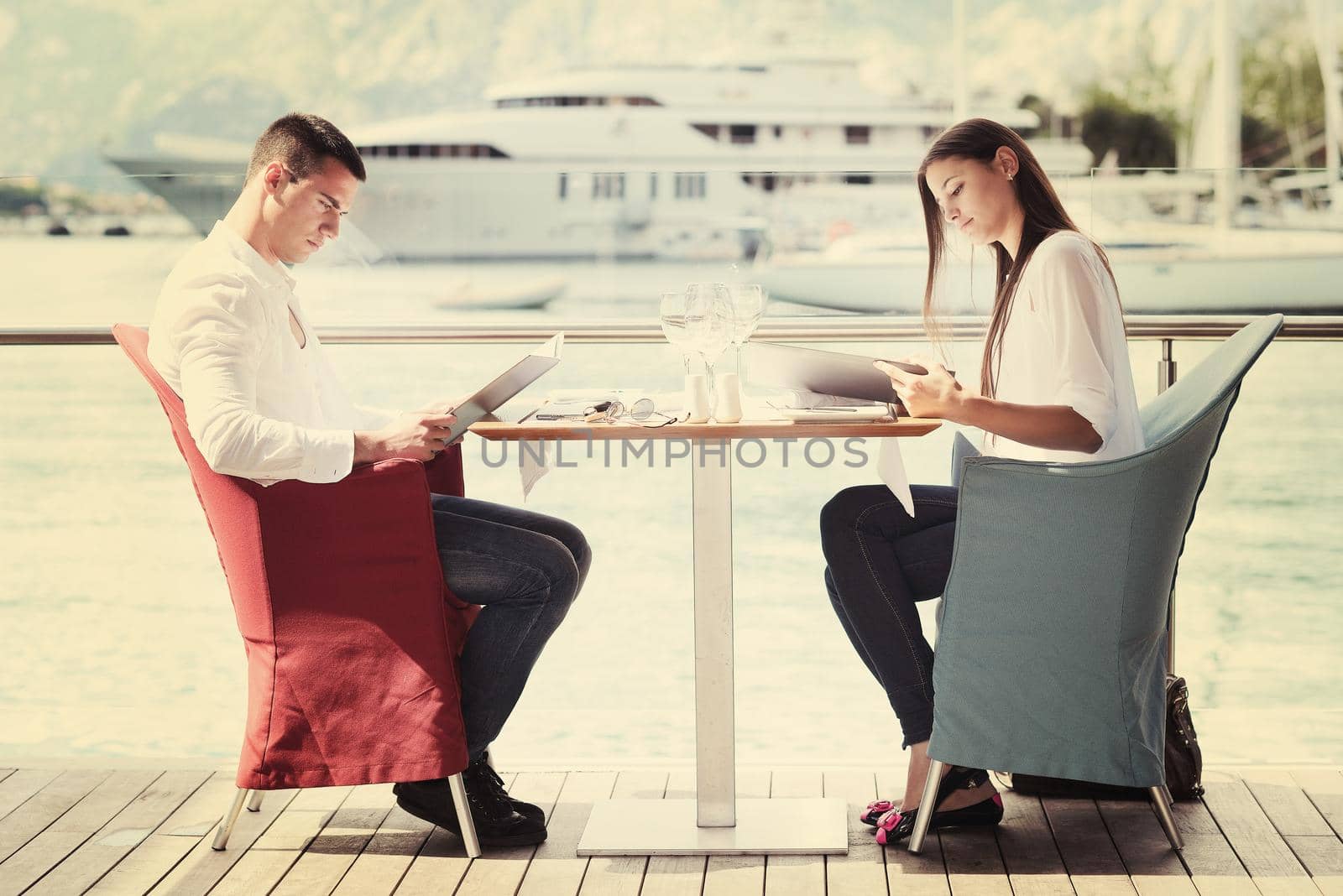 happy young couple having lanch at beautiful restaurant on by the sea on  beach