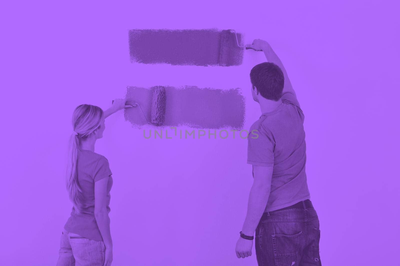 happy young couple paint in green and blue color white wall of their new home duo tone