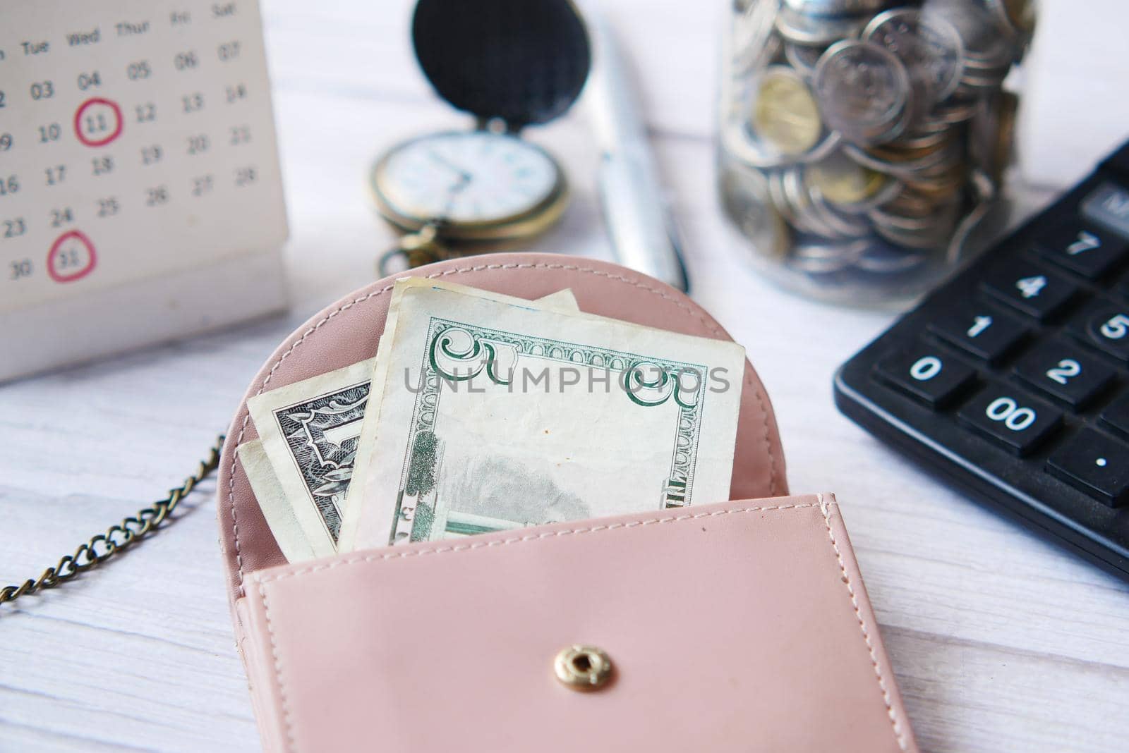 us dollar cash in leather on pink background .