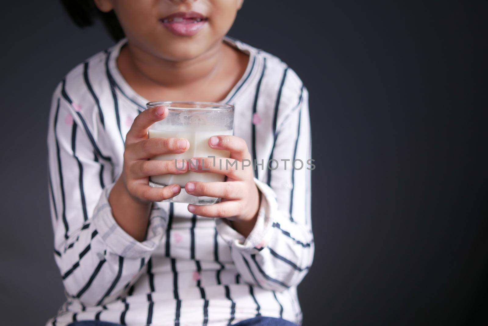 child girl drinking milk while sited . 6 year old