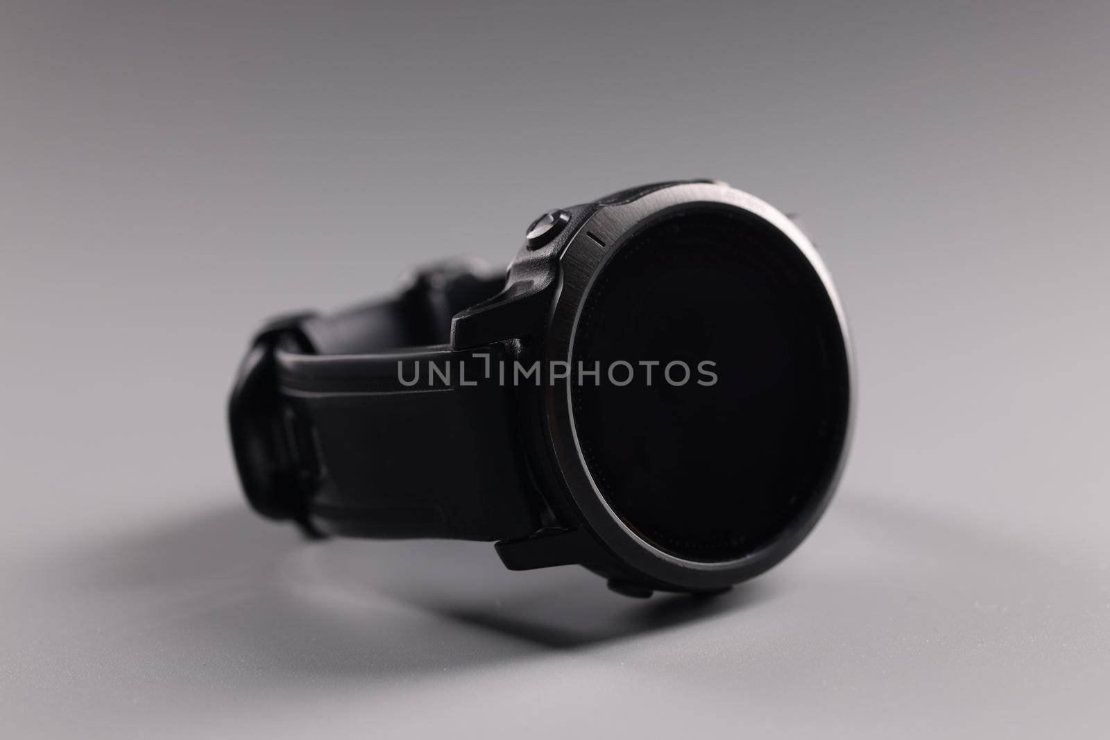 Male wrist sports watch lying on gray background closeup. Sale of accessories for men concept