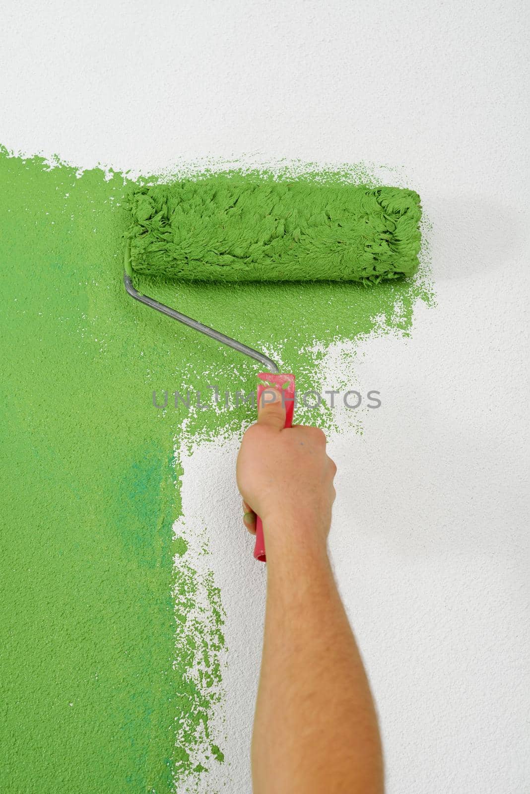 handsome young man paint in blue and green color  white wall of new home