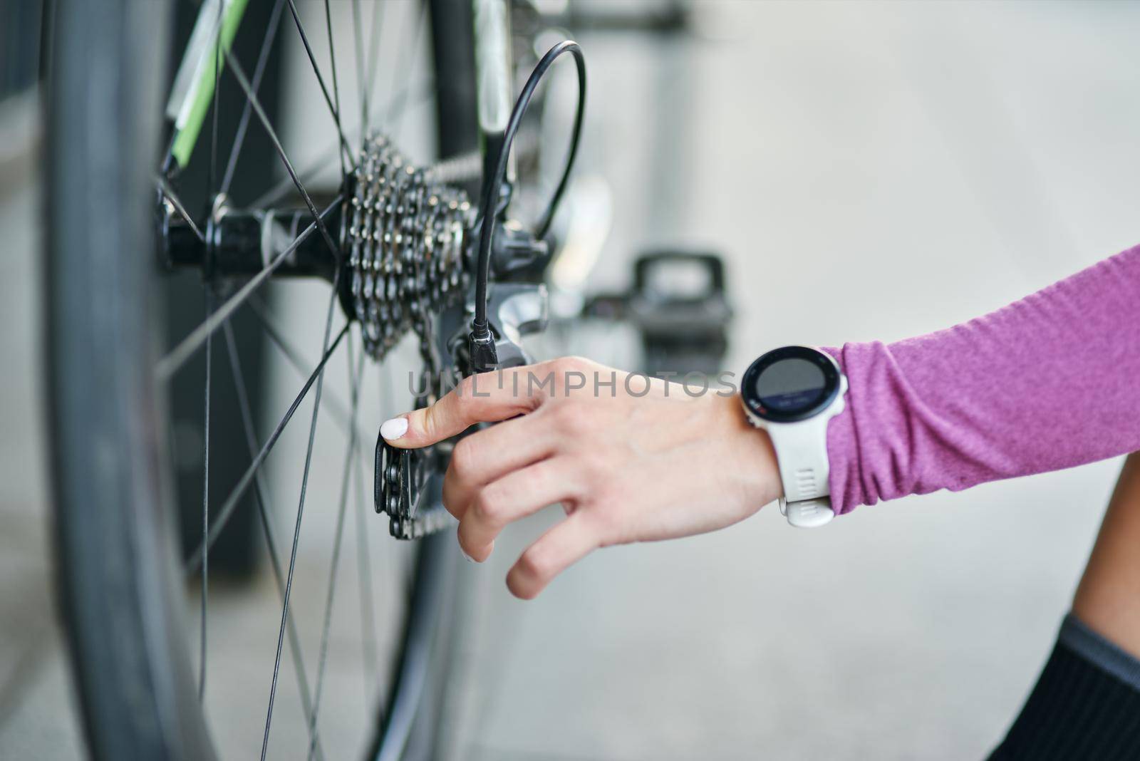 Close up shot of hand of female cyclist checking her bicycle mechanisms, sprocket and chain on a mountain bike outdoors on a daytime by friendsstock