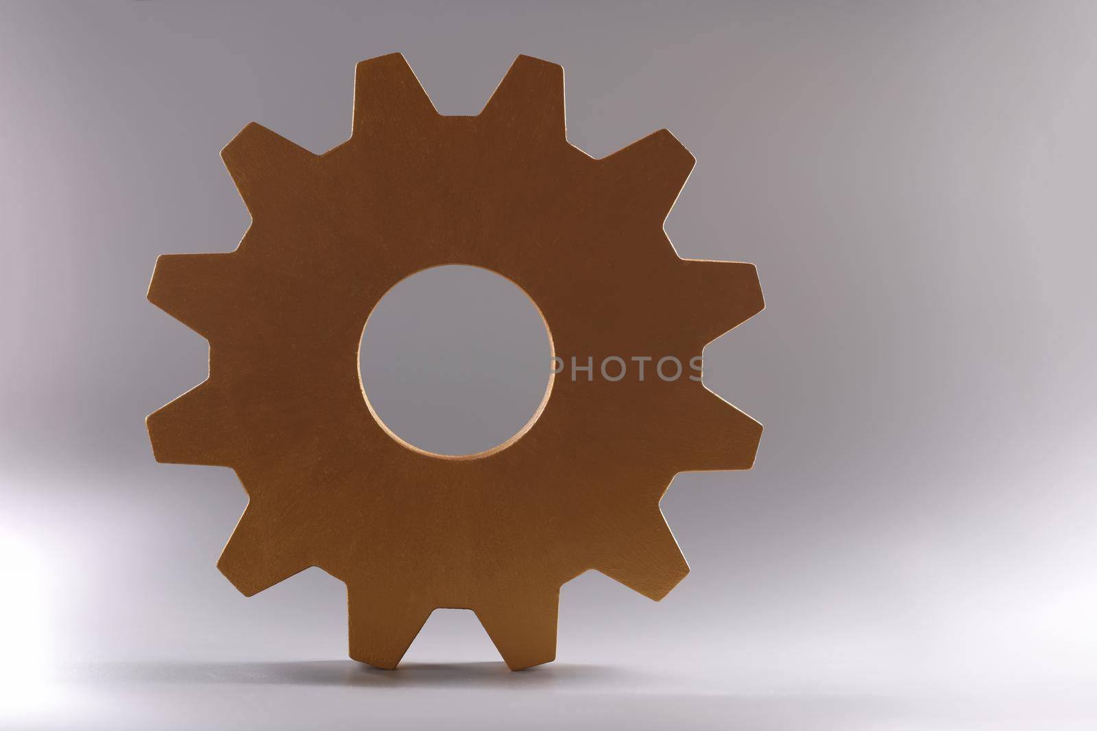 Golden detail of gear wheel of mechanism lying on gray background closeup. Repair of mechanical products concept