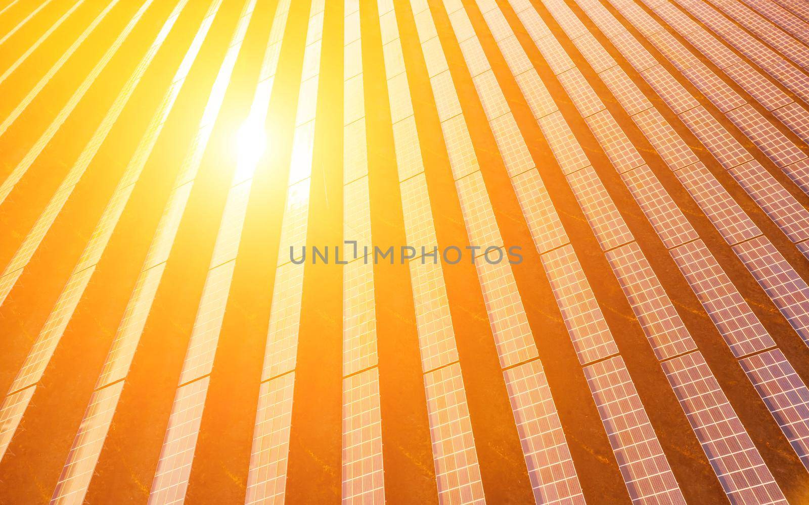 Aerial top view of a solar panels power plant. Photovoltaic solar panels at sunrise and sunset in countryside from above. Modern technology, climate care, earth saving, renewable energy concept