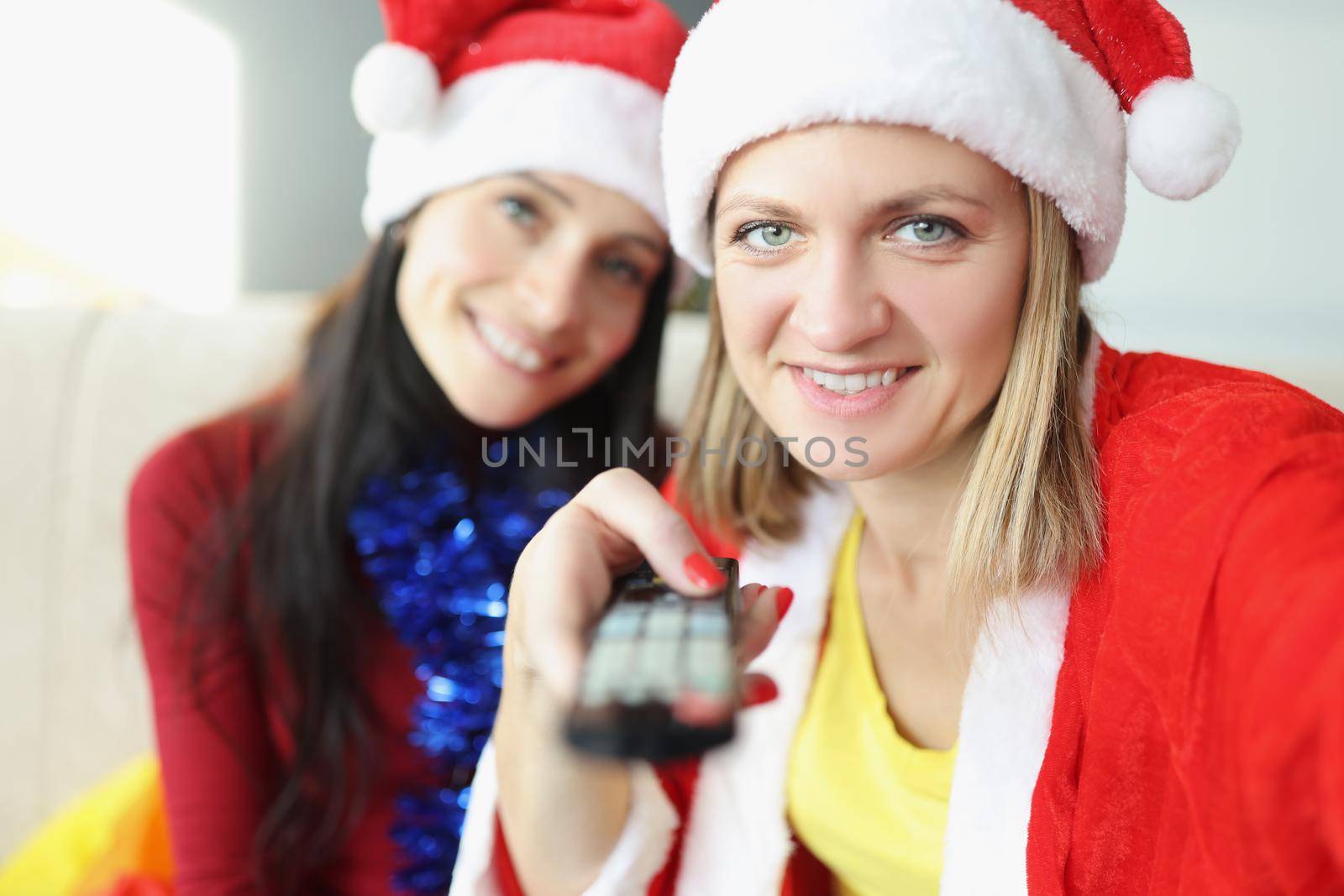 Portrait of friends holding remote control and switch to next year. Control your life, take decision, new year holiday, festive, fun, television concept