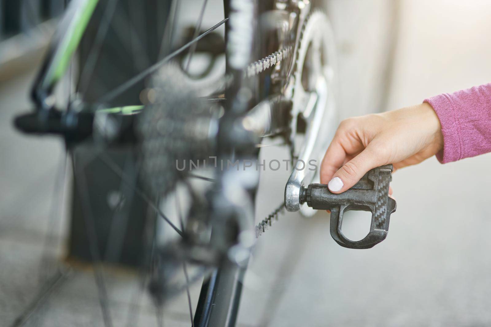Close up shot of hand of female cyclist checking her bicycle mechanisms, sprocket and pedal on a mountain bike outdoors on a daytime. Safety, sports, active lifestyle concept