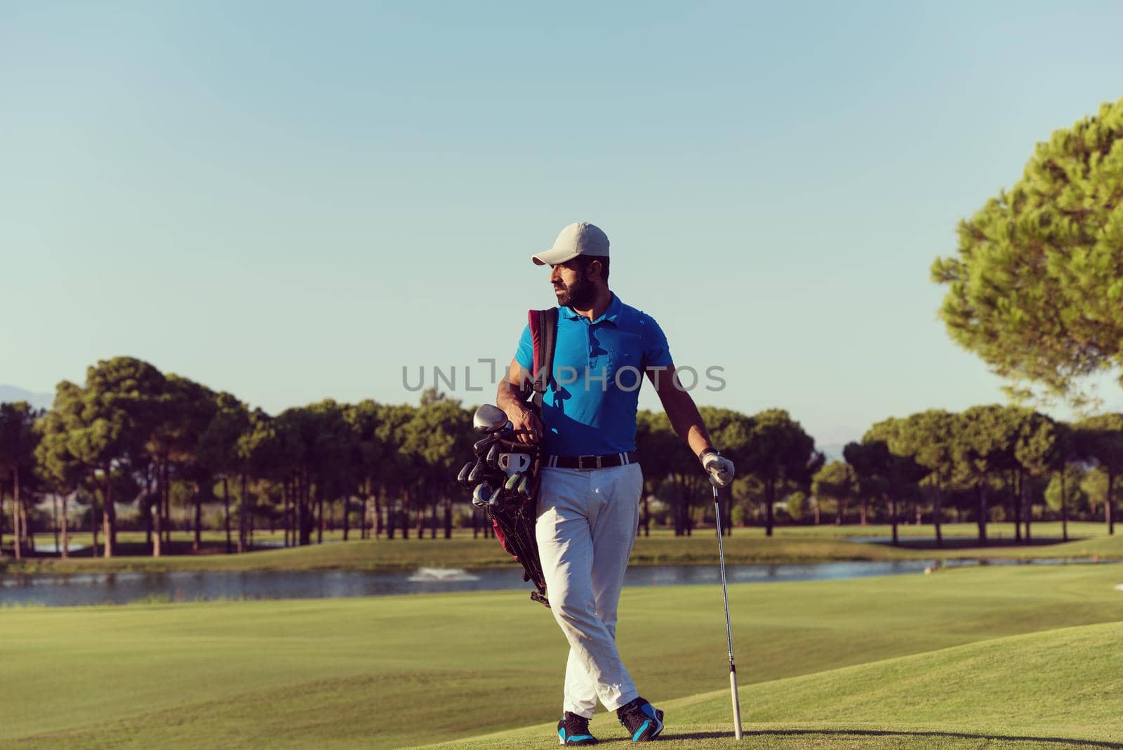 handsome middle eastern golf player portrait at course at sunny day