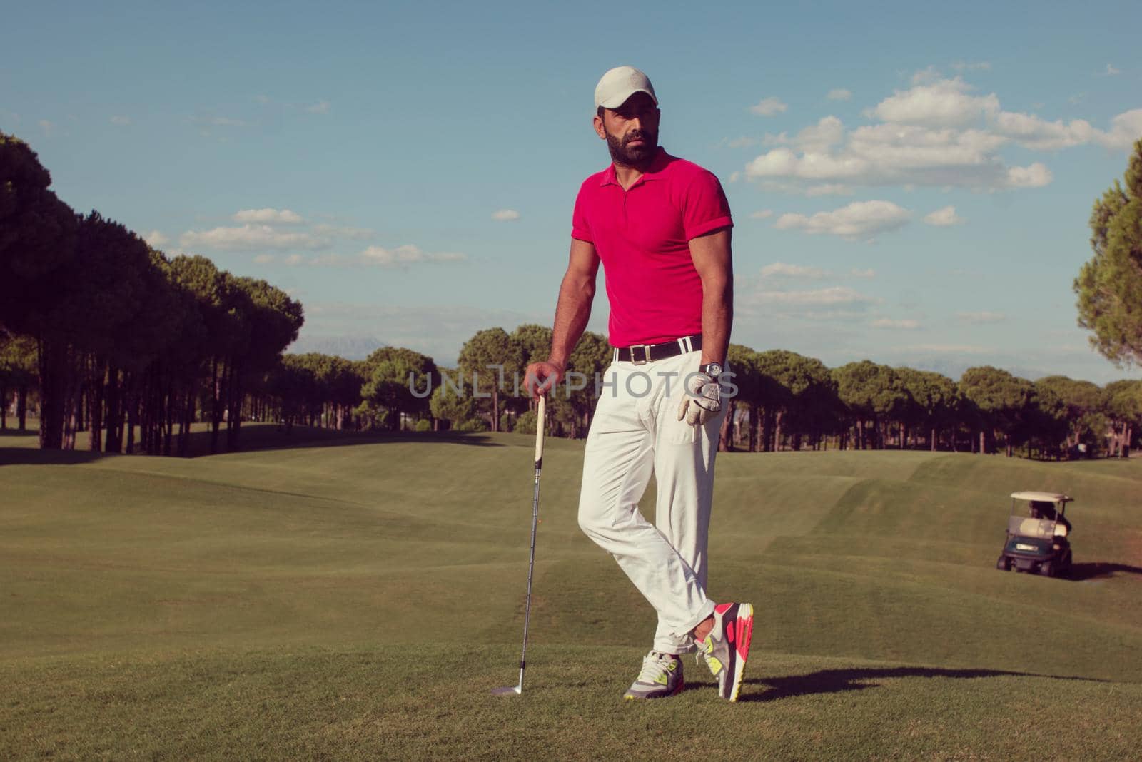 handsome middle eastern golf player portrait at course on beautiful sunset in background