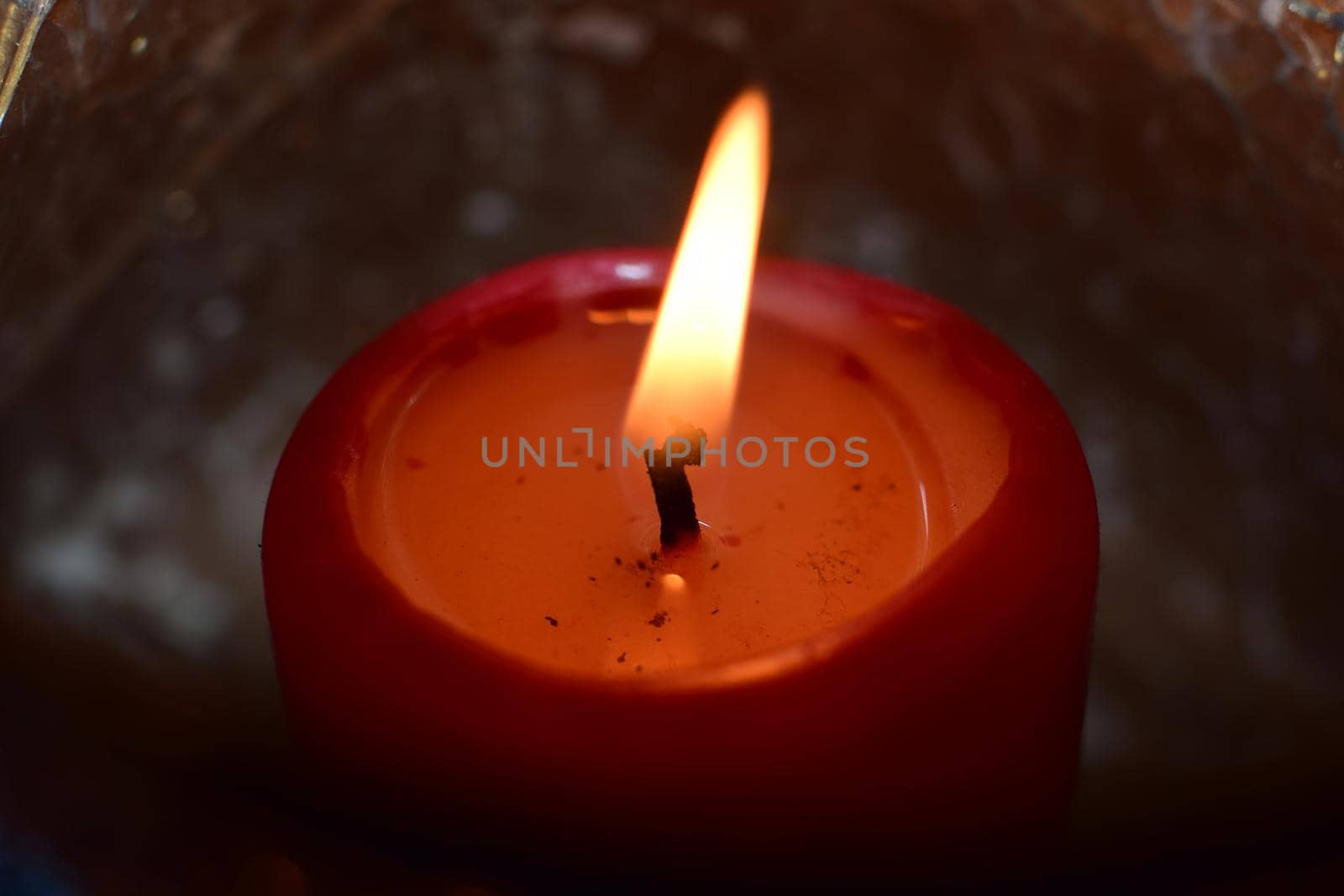 Burning red candle as a close-up