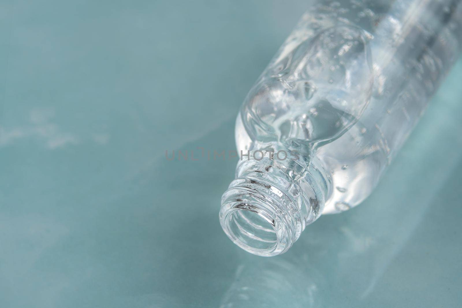 Transparent opened glass dropper bottle with bubbles on marble background. Pipette with fluid hyaluronic acid, serum, retinol or oil. Cosmetics and healthcare concept. Flat lay. Luxury beauty product