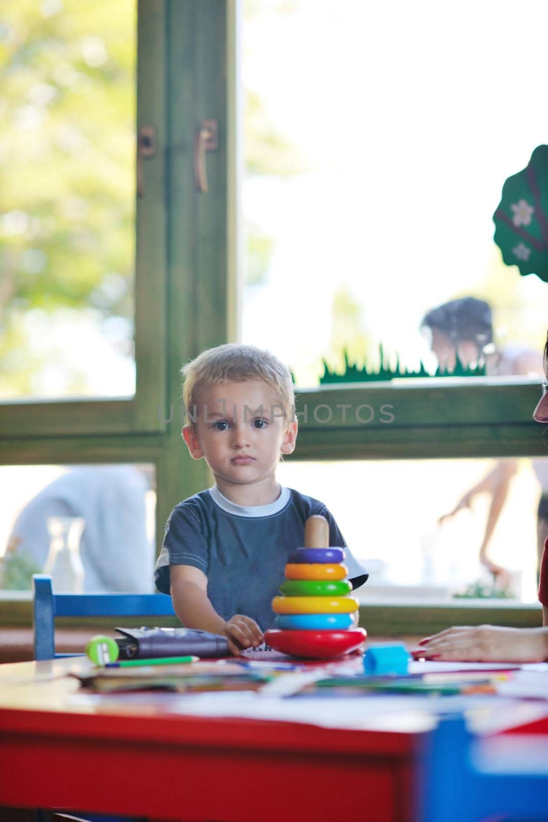 happy little child play game and have fun, education lessons in colorful kinder garden playground indoors