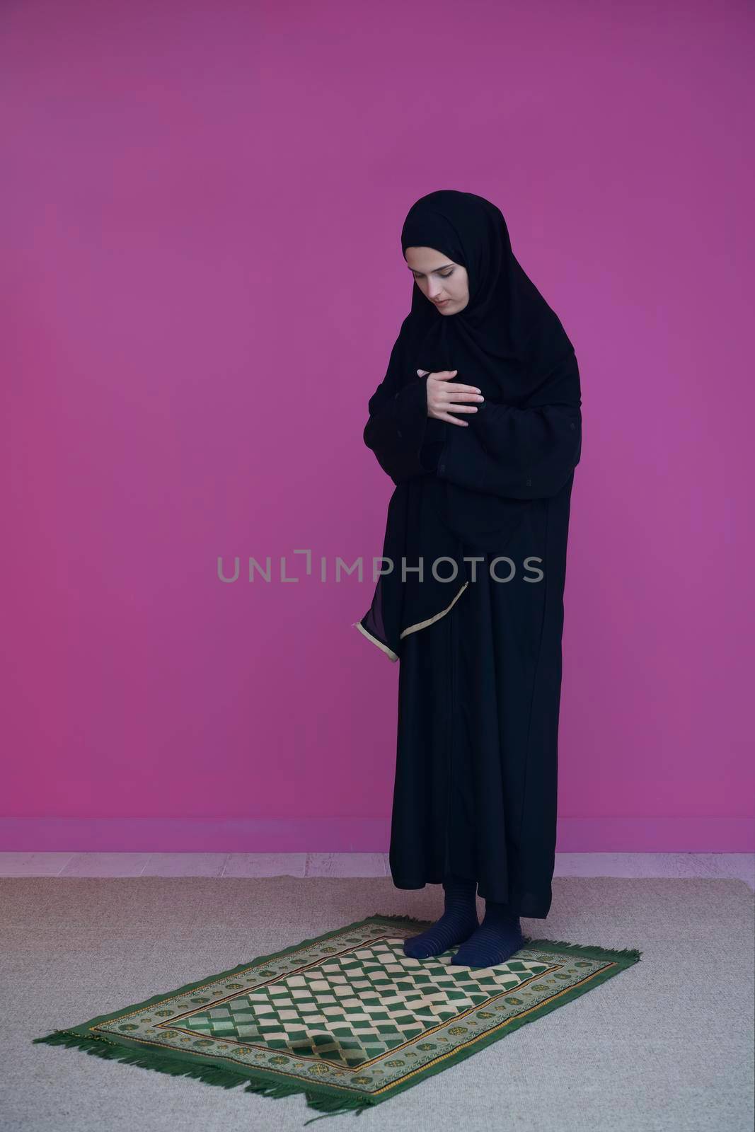 Muslim woman in namaz praying to Allah, God. Muslim woman on the carpet praying in traditional middle eastern clothes, Woman in Hijab