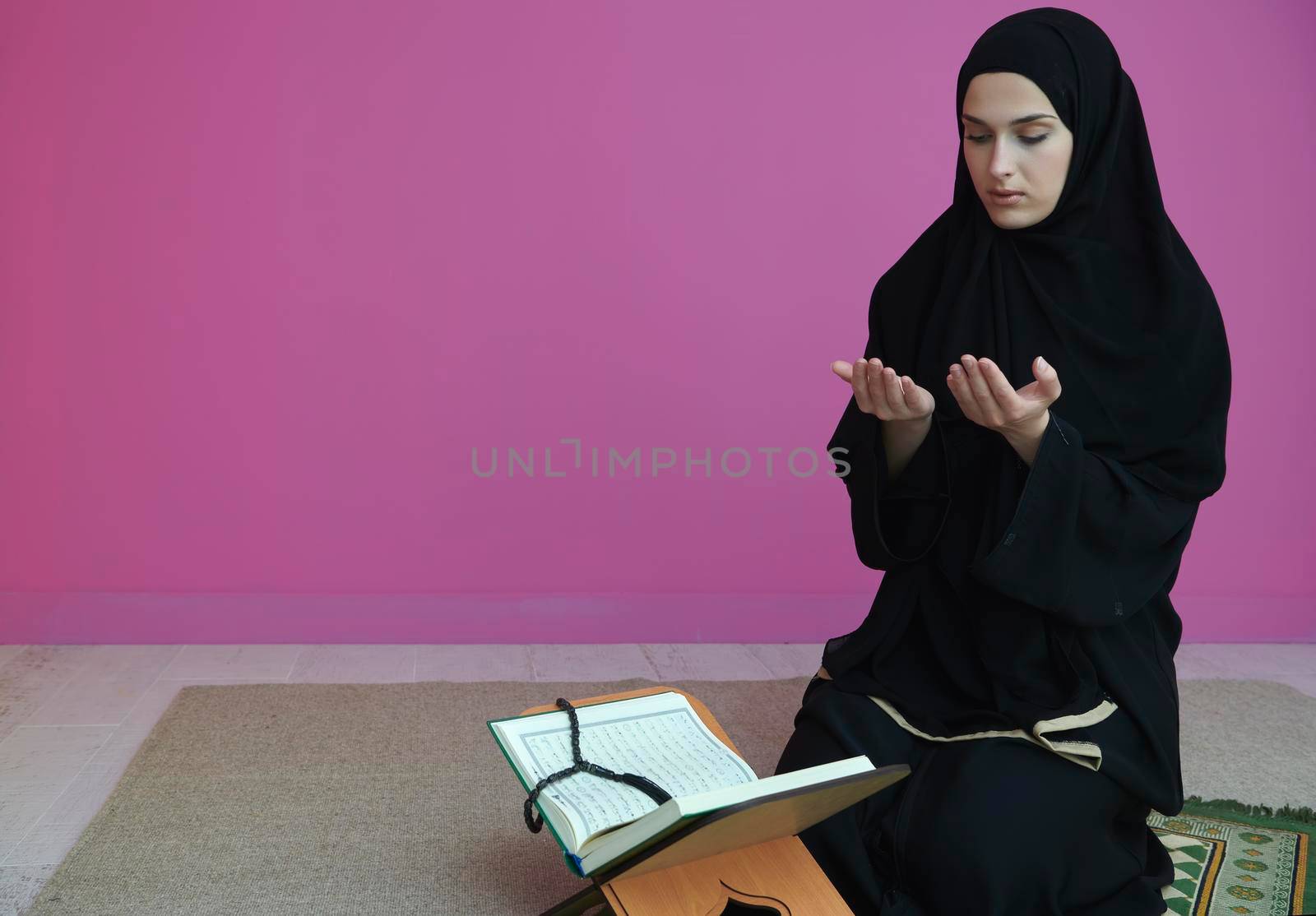 Middle eastern woman praying and reading the holy Quran by dotshock