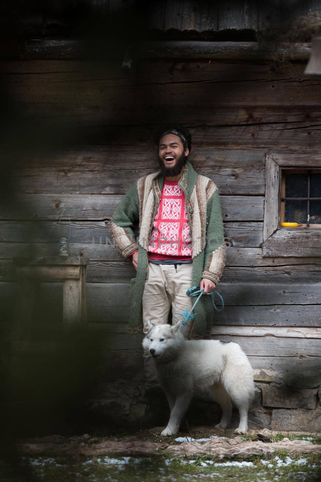 hipster with dog in front of wooden house by dotshock