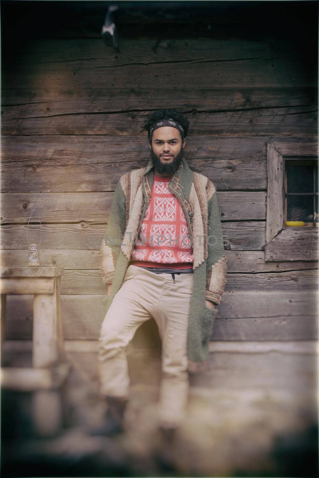 portrait of young hipster in front of wooden house by dotshock