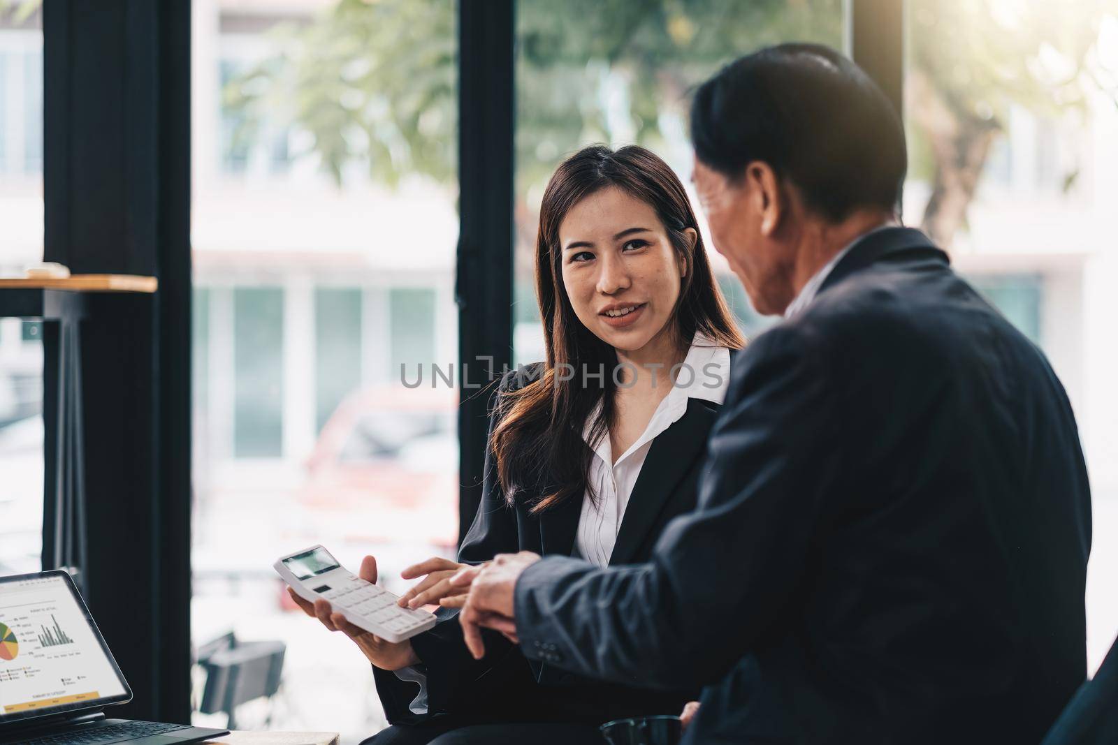 Senior man planning their investments with financial advisor, Young female consultant with calculator.