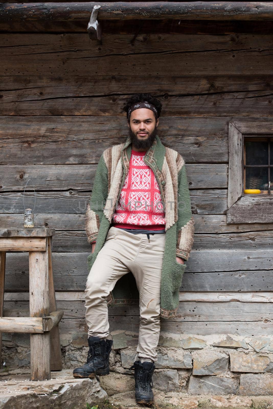 portrait of young hipster in front of wooden house by dotshock