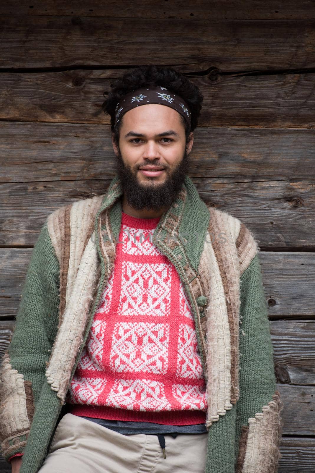 portrait of young hipster in front of wooden house by dotshock