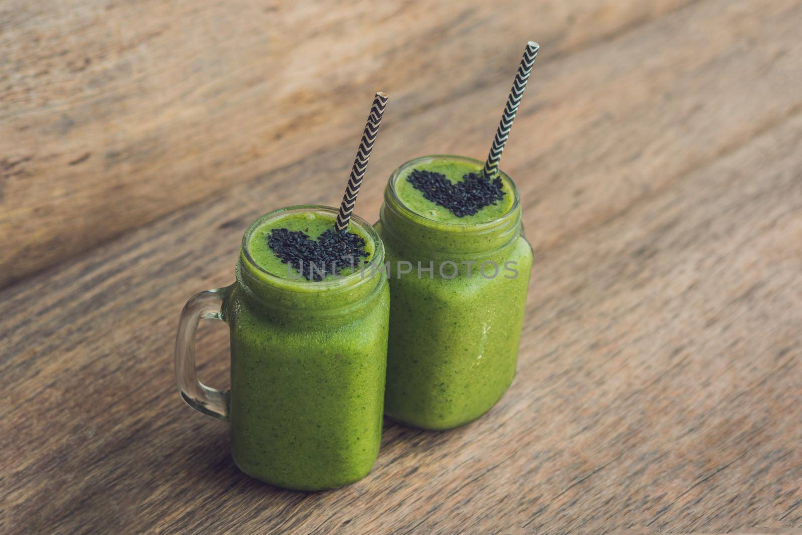 Fresh green smoothie with banana and spinach with heart of sesame seeds. Love for a healthy raw food concept.