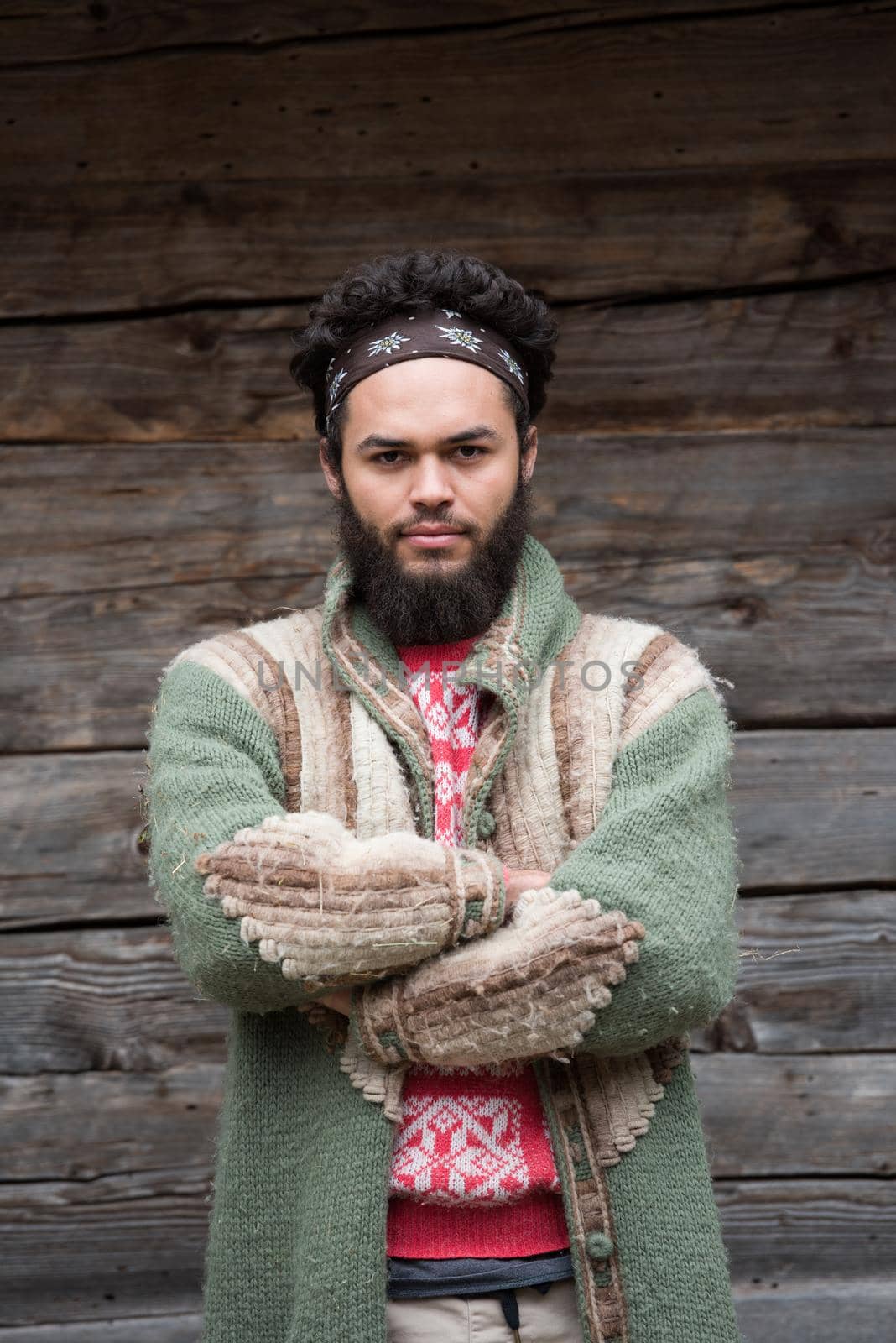 portrait of young hipster,  man with beard in front of old vintage wooden house